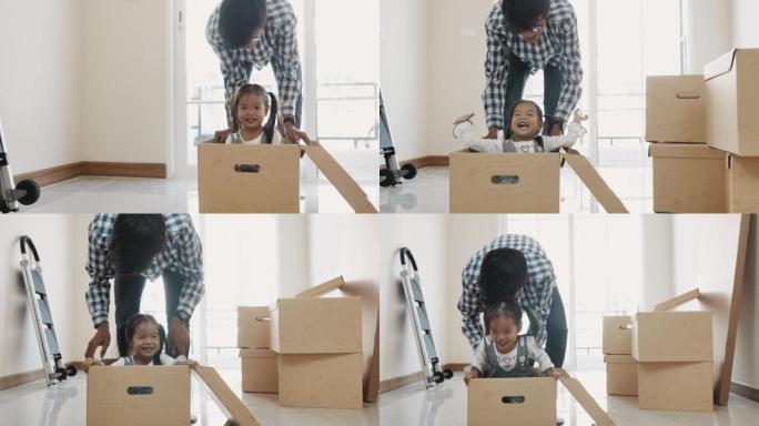 家庭搬家，父亲用小孩推着纸箱