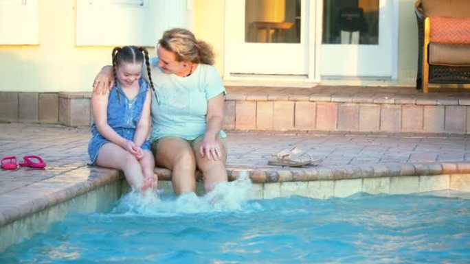 患有唐氏综合症的女孩，母亲坐在游泳池旁