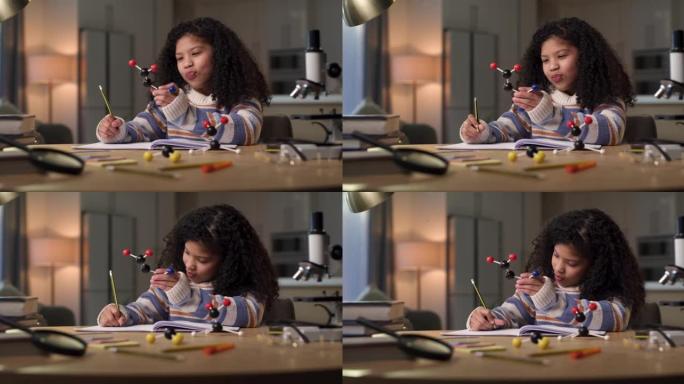 4k视频片段，一个年轻女孩独自坐在家里，在做科学作业时看起来很沉思