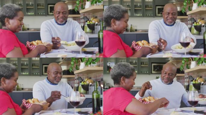 快乐的非洲裔美国老年夫妇在厨房一起吃饭