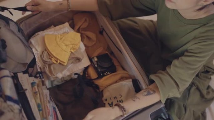 亚洲妇女在假期回家打包行李箱。