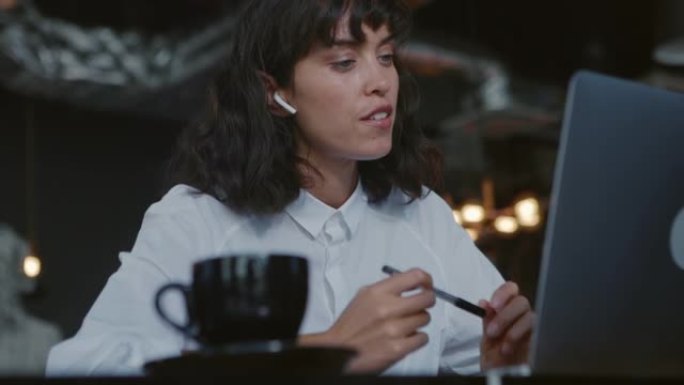 咖啡馆的视频会议蓝牙耳机思考女性工作