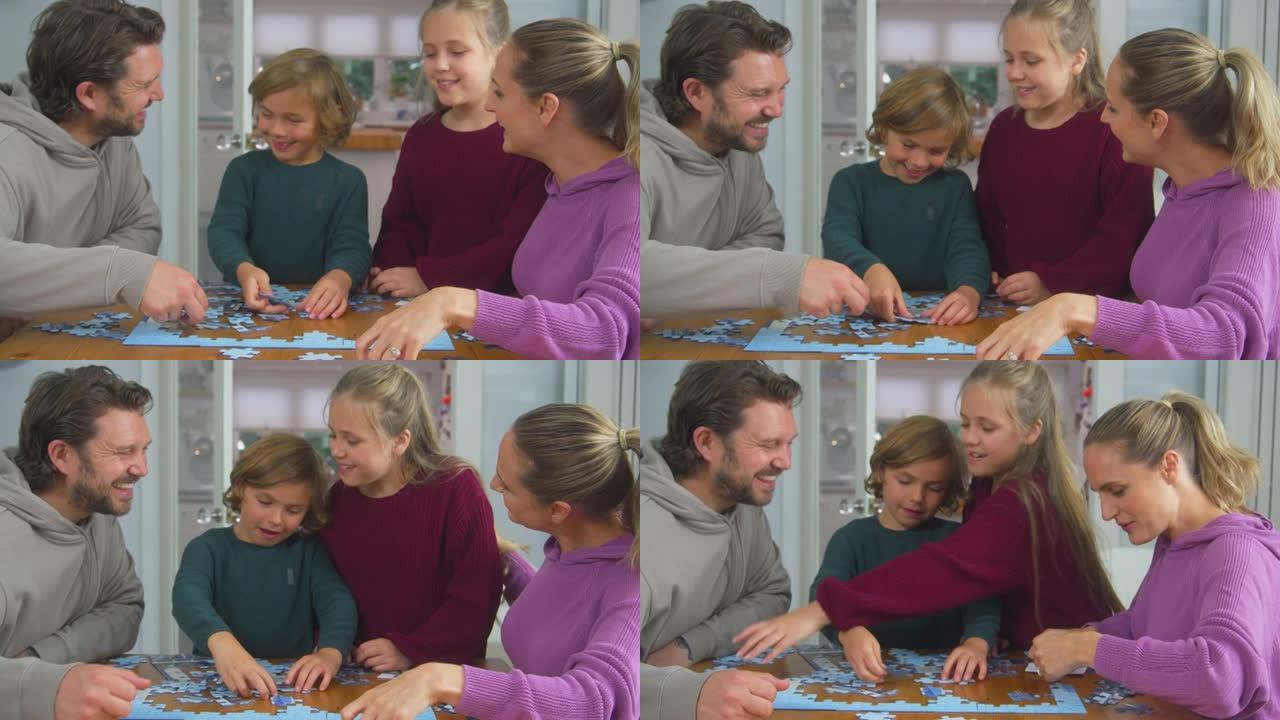 有孩子的家庭坐在家里的桌子旁一起做拼图游戏