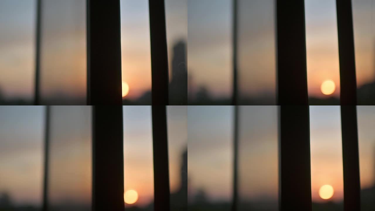 散焦日落透过窗户看城市，日落太阳反射窗户