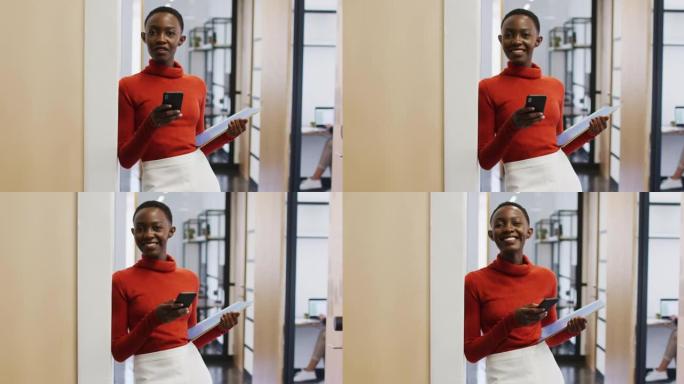 非裔美国妇女在办公室使用智能手机时微笑的肖像