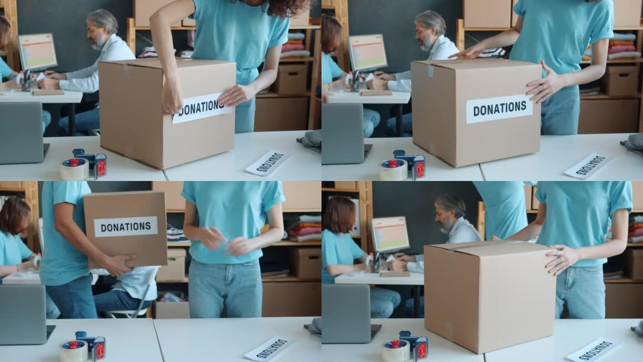 慈善公司活动家为办公室捐赠准备纸箱的特写