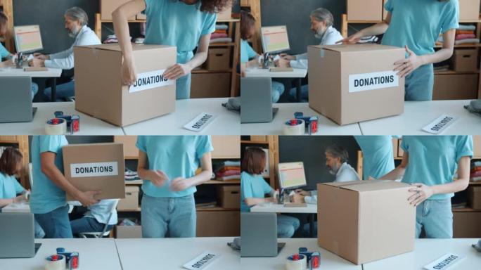 慈善公司活动家为办公室捐赠准备纸箱的特写