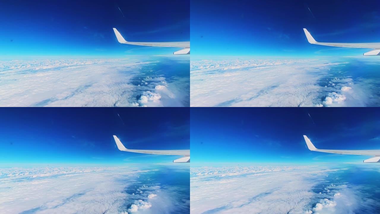 坐飞机飞行。飞机机翼在美丽的云层和蓝天下的景色