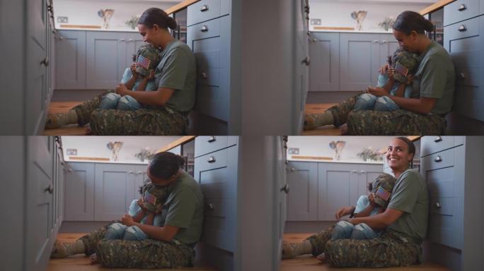 休假回家的美军母亲抱着坐在厨房地板上穿着军装的儿子——用慢镜头拍摄