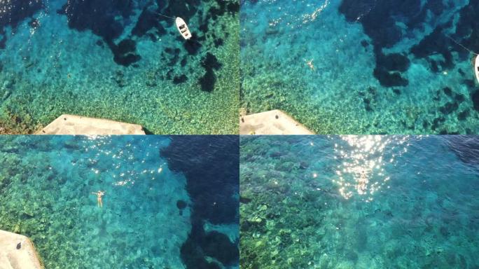 空中女子在亚得里亚海的绿松石水中游泳