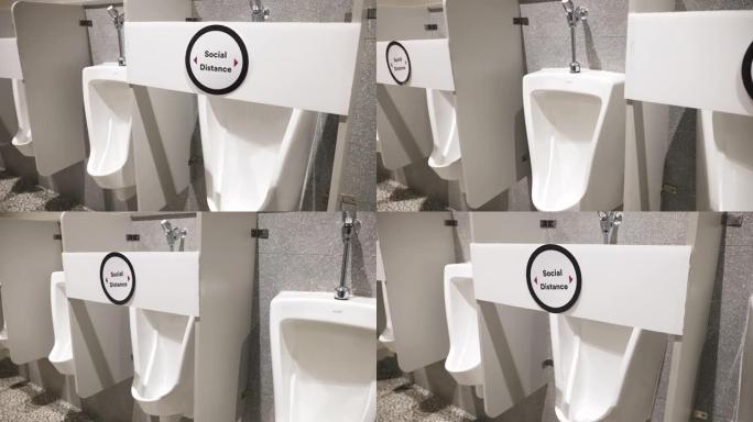 带有社交距离标志的男性公共厕所中的小便池。