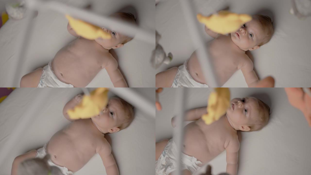 SLO MO婴儿男孩看着婴儿床玩具
