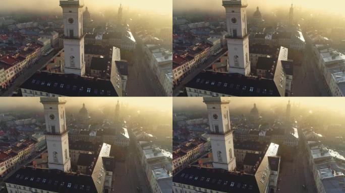 飞越早晨多雾的乌克兰利沃夫市。风景秀丽的夏季鸟瞰图的市场广场建筑在老城利沃夫，乌克兰。市政厅和市场广