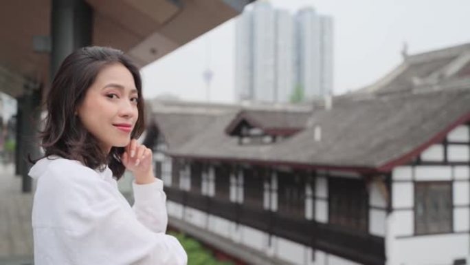 可爱的中国女孩在城市的镜头前微笑