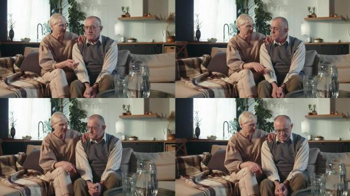 团结概念。70岁退休老人的肖像，夫妻微笑，坐在家里的沙发上聊天