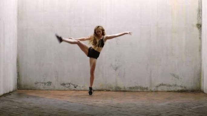 舞蹈，跳跃和城市自由，一个女子舞者独自在铺路。健康，健身和能量，一个在动人表演中跳舞的女孩。平衡、训