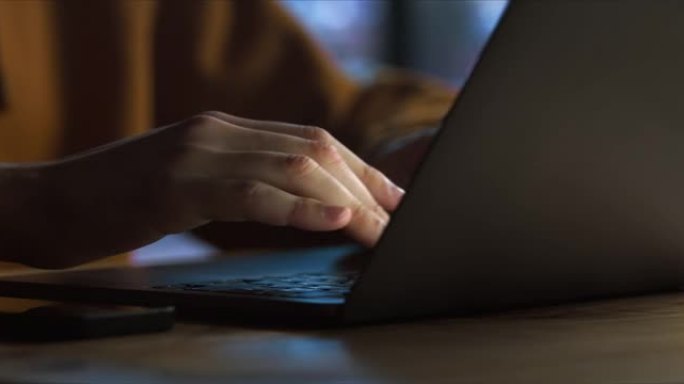 一台笔记本电脑和一个男人的手，在上面打字