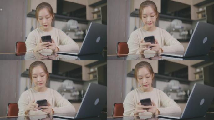 美丽的亚洲年轻女子年龄36岁，在家工作，手提电脑，早上在家用手机。成人在线学习概念。与阿尔法香奈儿。