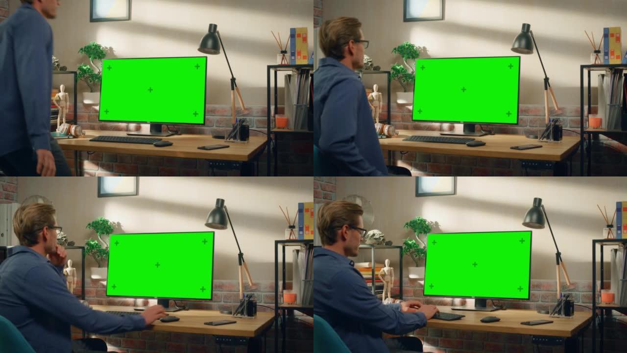 年轻英俊的男人坐下来在家工作，台式电脑上有绿屏模拟显示。创意男性查看社交媒体，浏览互联网。明亮阁楼公