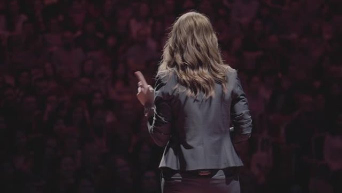 自信成功的女教师在大学课堂学生演讲。演讲人在观众面前演讲。教育经理礼堂的后视图舞台公共演讲教练