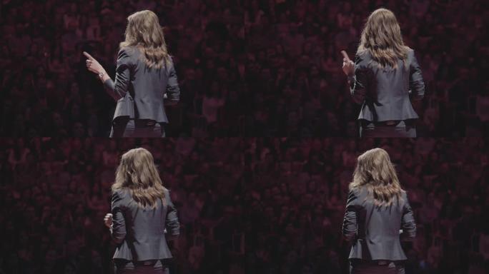 自信成功的女教师在大学课堂学生演讲。演讲人在观众面前演讲。教育经理礼堂的后视图舞台公共演讲教练