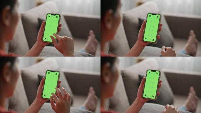 女性在家中使用绿屏模板智能手机