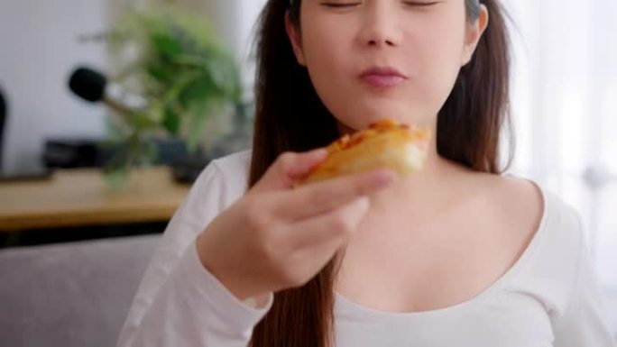 孕妇在家吃披萨不健康的食物。