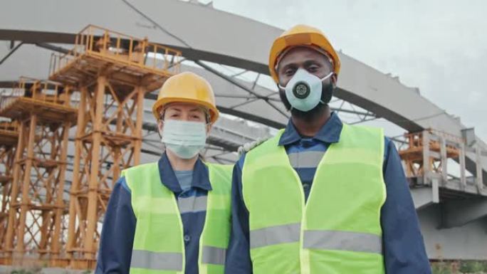 戴口罩的多民族建筑工人摆姿势