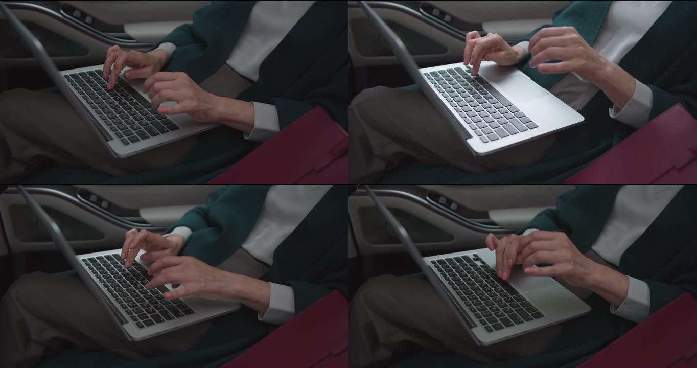 中年女性手的高角度视图，在笔记本电脑上打字，同时作为乘客乘坐汽车
