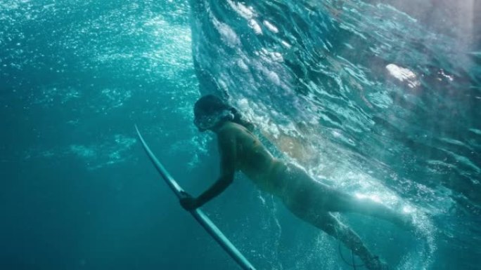 海浪下潜水的女冲浪者