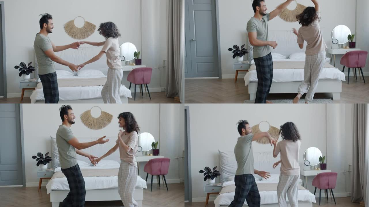 快乐的夫妻在卧室里跳舞，在家享受音乐和浪漫的时刻