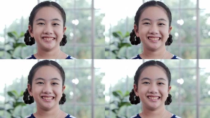 亚洲儿童女孩微笑自信的肖像看着相机独自在家摆姿势，带着快乐的心情享受成功的生活方式。家庭工作室
