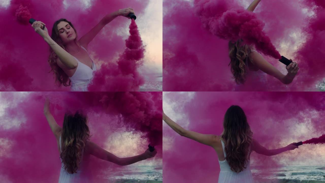 清晨，美丽的女人挥舞着粉红色的烟雾弹在海滩上跳舞，庆祝创意自由