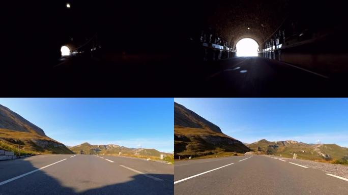 在山口公路上驶过隧道，隧道出口展示了周围令人惊叹的风景