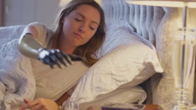 与躺在床上睡觉的假肢女人的夫妇被手机报警唤醒-慢动作拍摄