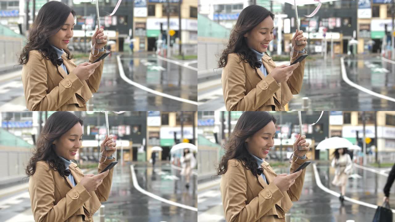 亚洲妇女在城市下雨时使用智能手机