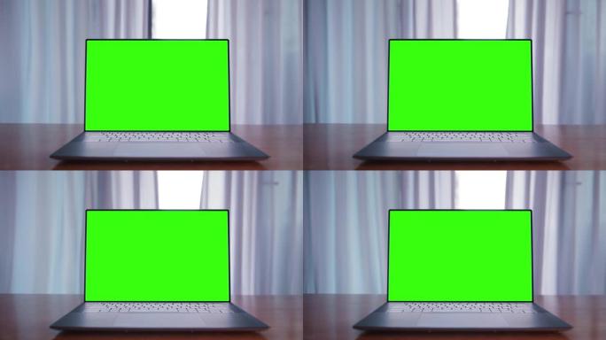 桌子上有绿色屏幕的笔记本电脑