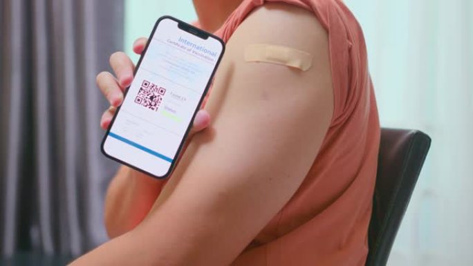 特写亚洲男子在接种疫苗后在智能手机上展示国际新型冠状病毒肺炎疫苗接种证书
