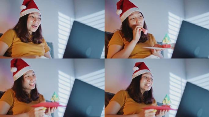 亚洲妇女使用笔记本电脑在晚上通过视频通话祝贺朋友或家人圣诞快乐