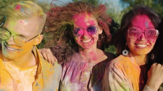 在洒红节上，快乐的年轻人朋友的肖像被粉末涂料覆盖在一起