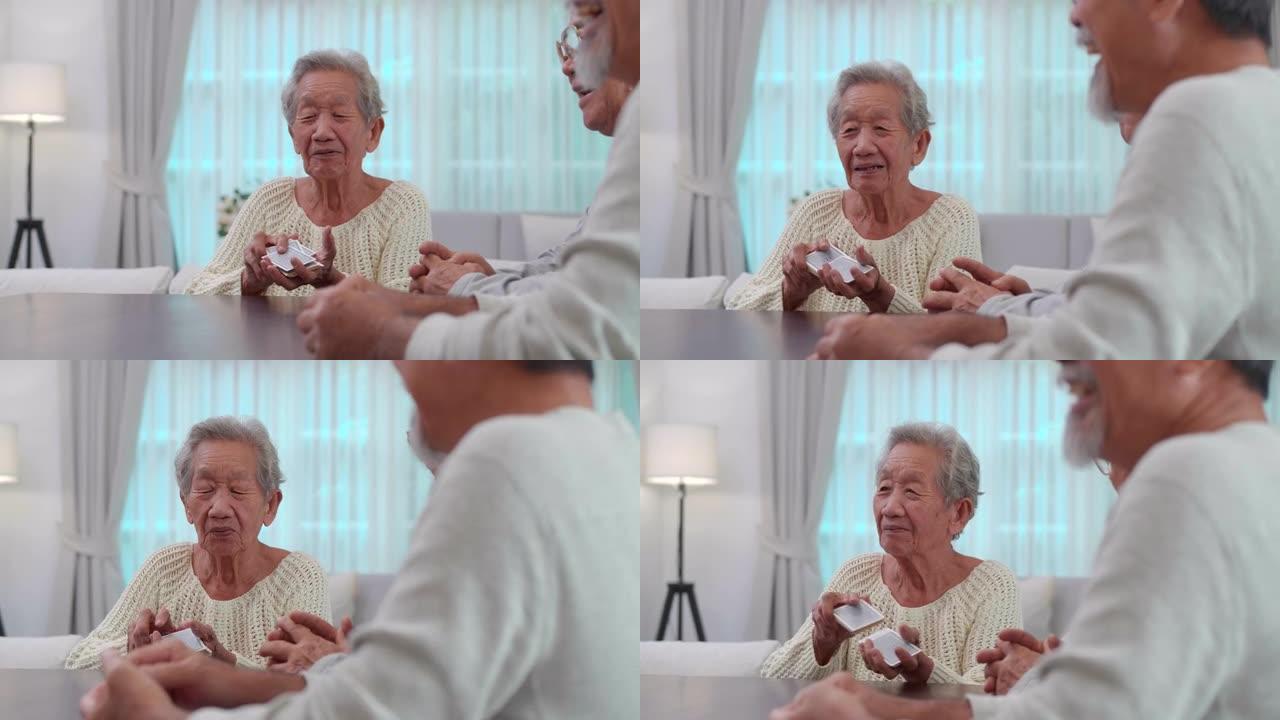 一群年龄在60-70岁之间的亚洲活跃老年人与一群快乐的老朋友在打牌的同时在疗养院度过了愉快的时光。社