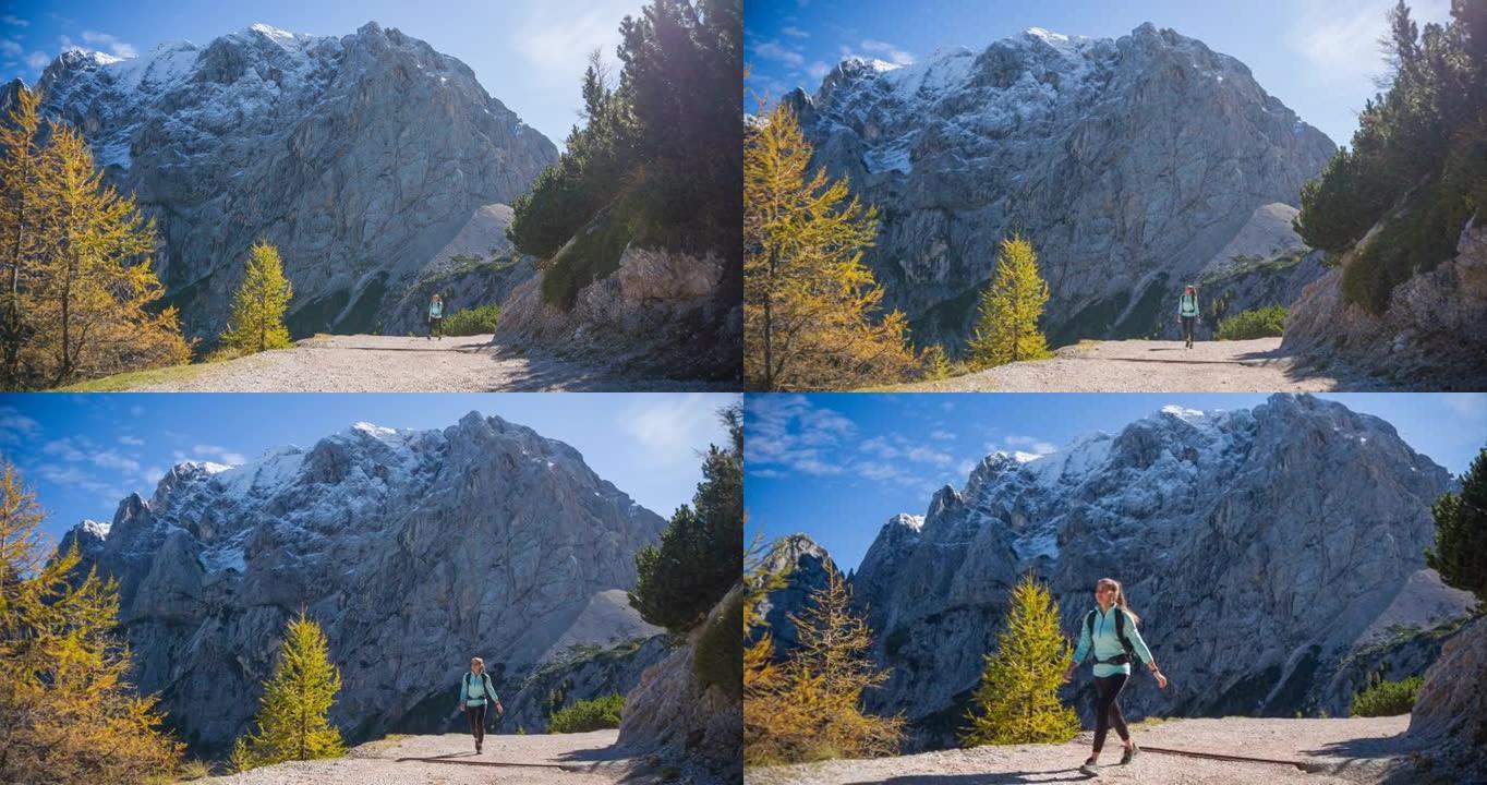 年轻的健身女子保持健康，在山上呼吸新鲜空气，徒步旅行