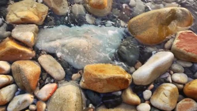 沿海岸线的石头上的水的慢动作视图。