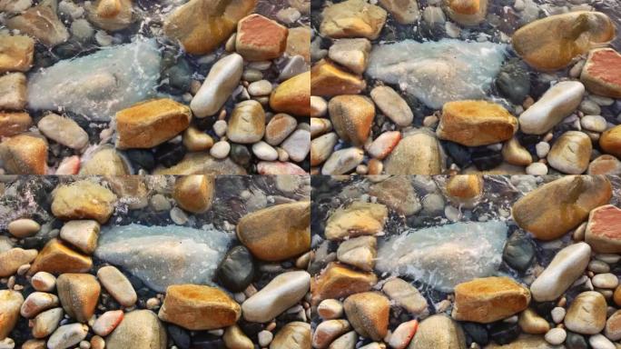 沿海岸线的石头上的水的慢动作视图。