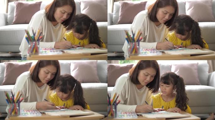 母亲在家教女儿在客厅画画和做作业