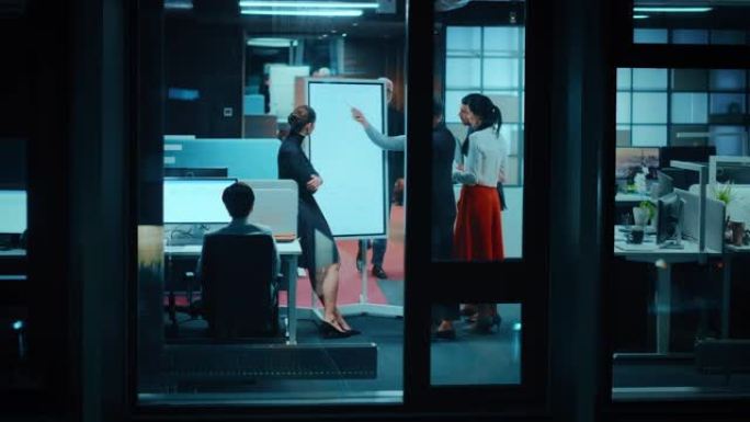 窗外的镜头: 办公室的日常会议。开发经理介绍了数字白板，向年轻的金融专家解释了新的业务策略。