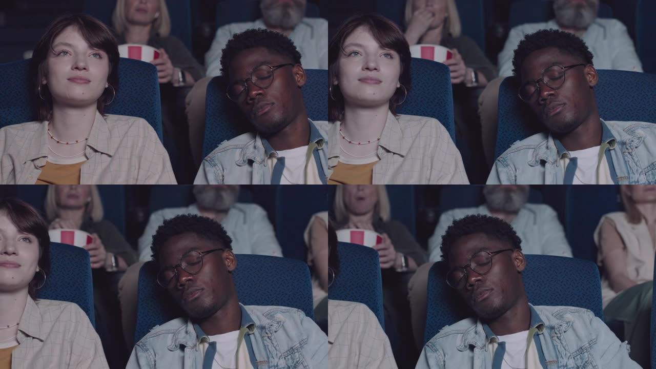 年轻女子和她昏昏欲睡的男友在电影院