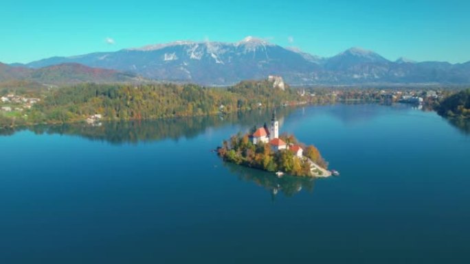 空中: 秋天在小岛上放满山背景和教堂的湖流血