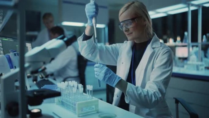 女性研究科学家在现代实验室中使用微量移液管在样品试管中混合液体。科学家们正在技术、显微镜和计算机的帮