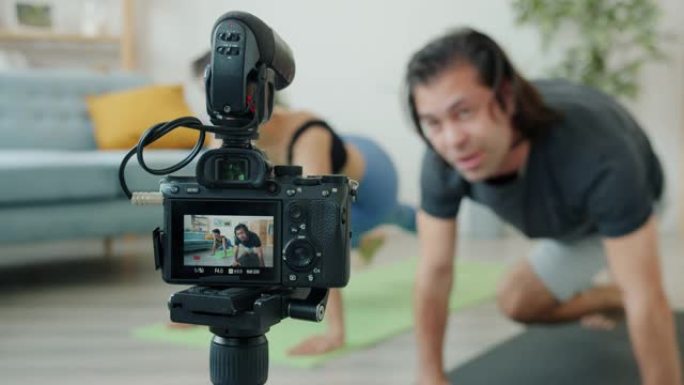 快乐的亚洲男人和白人女人在家里做运动和录制视频